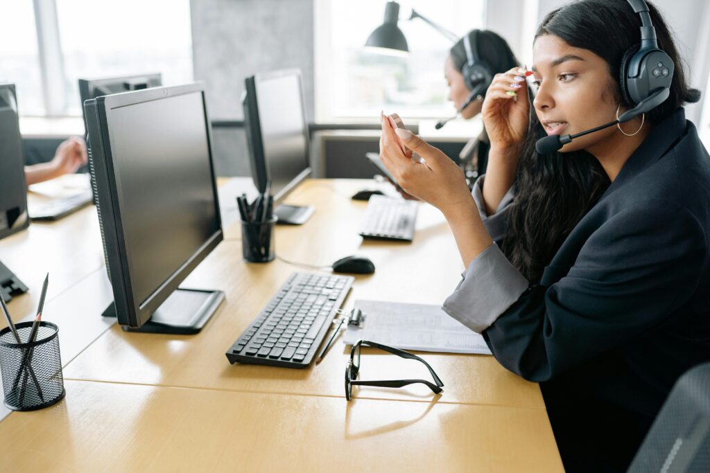 Woman Wearing Headset Sitting in Front of a Computer